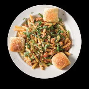 Oval plate of creamy pasta with meat, herbs, cheese, and three rolls.