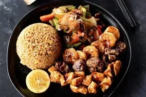 Hibachi-style plate with fried rice, vegetables, and mixed proteins.