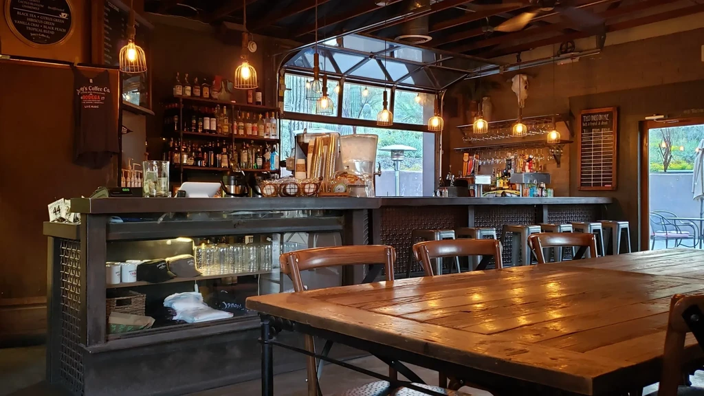 Rustic bar interior with a communal table and warm, inviting light.