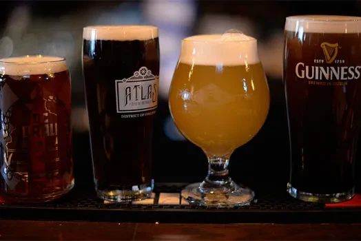 Four diverse beers, Atlas and Guinness, in glasses on a mat.
