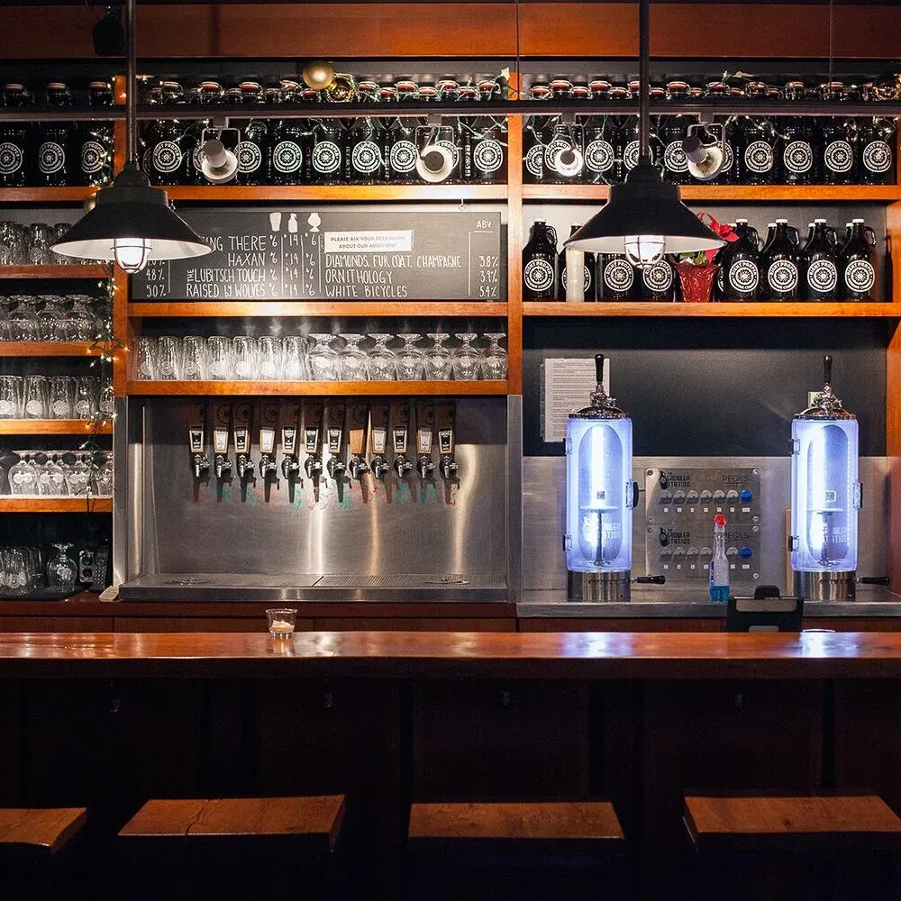 Extensive craft beer bar with taps, bottles, menu, and crowler station.