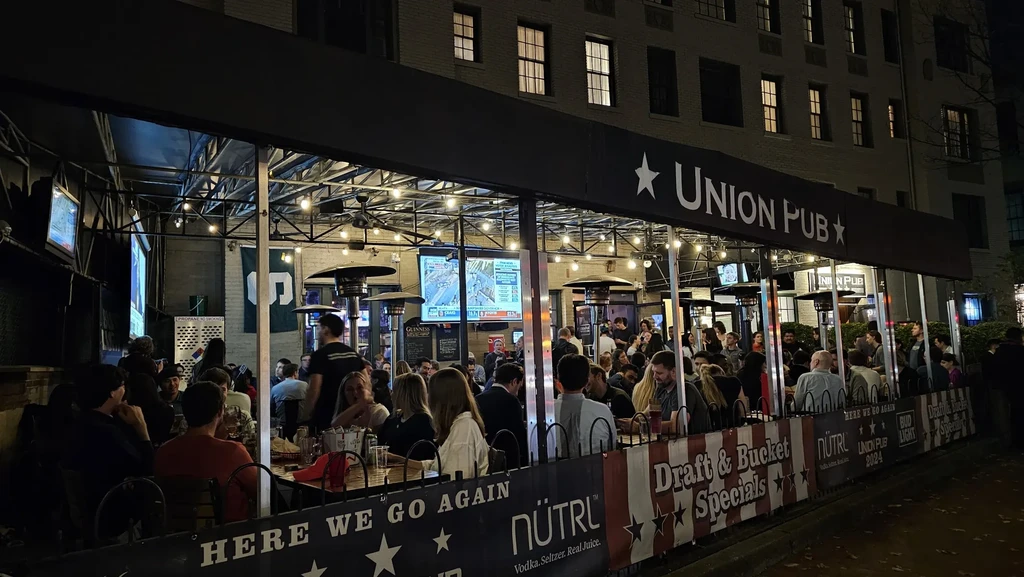 Union Pub's lively outdoor patio at night, full of diners.