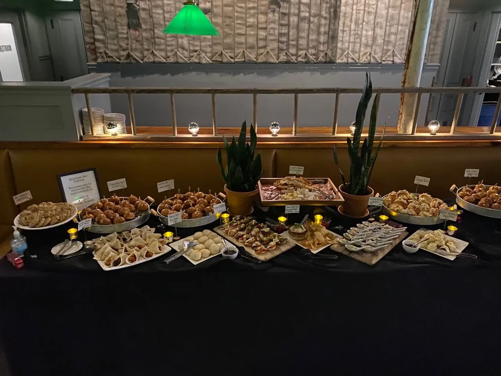 Buffet table indoors, featuring appetizers, charcuterie, and desserts.