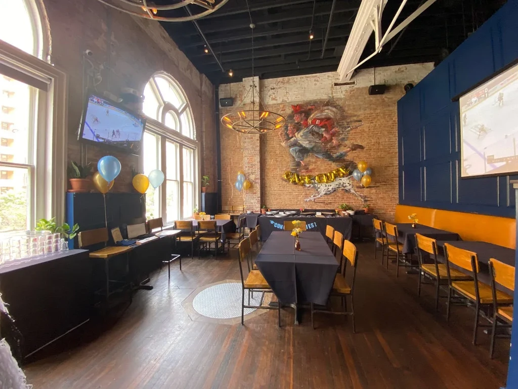 Restaurant interior decorated for a party, with 'CONGRATS' and sports.