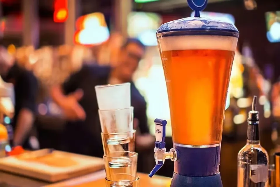 Bud Light beer tower with amber beer, foam, and stacked glasses.