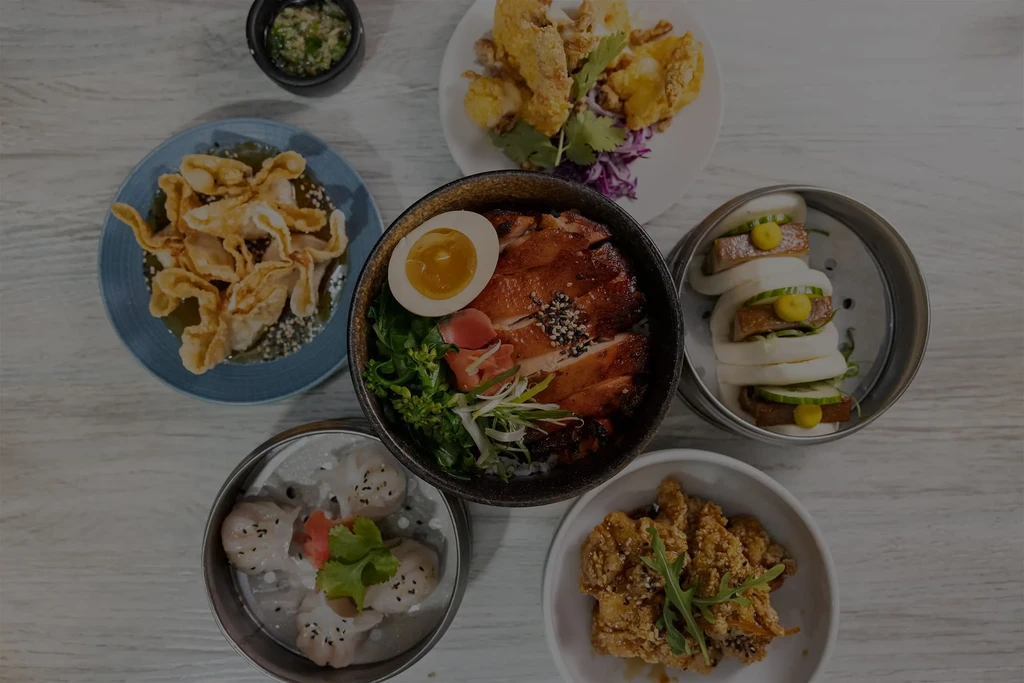 Overhead shot of a table with a variety of vibrant Asian dishes.