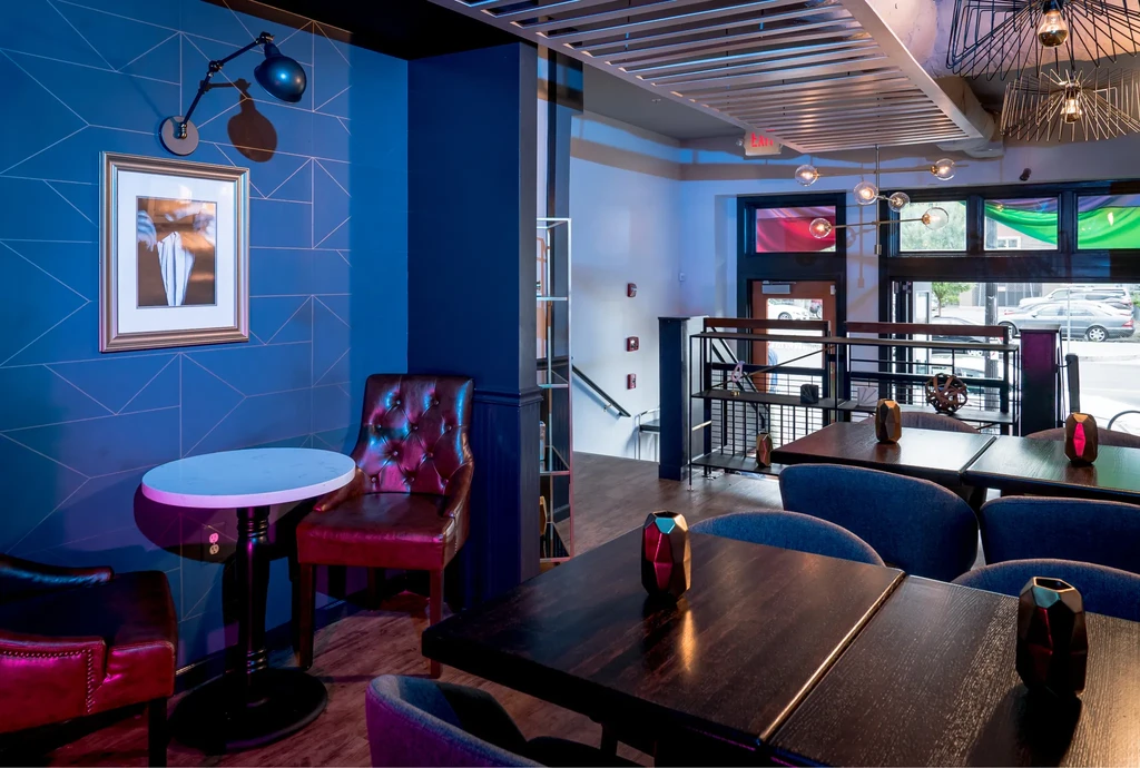 Modern restaurant interior with diverse seating and urban views.