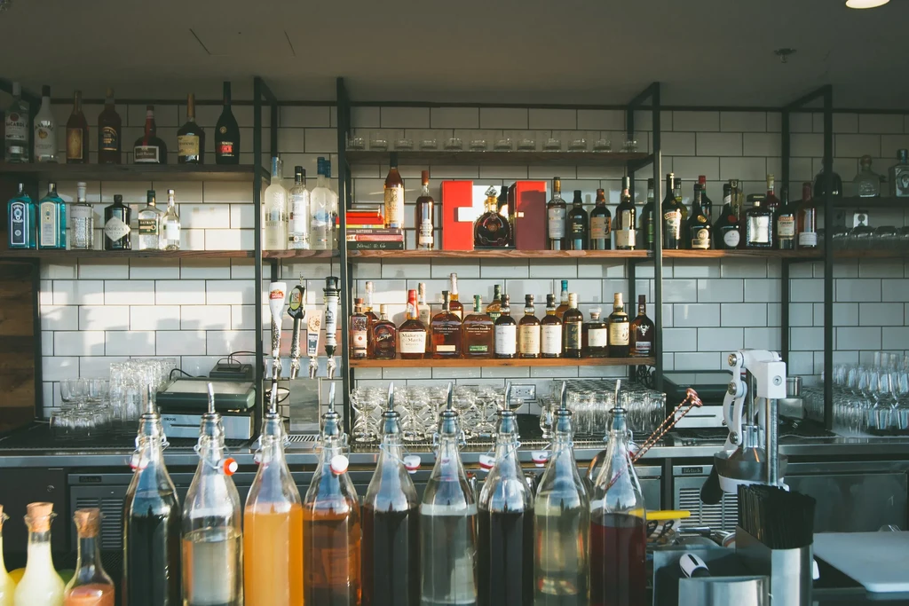 Well-stocked, modern bar with spirits, mixers, glasses, and bar tools.