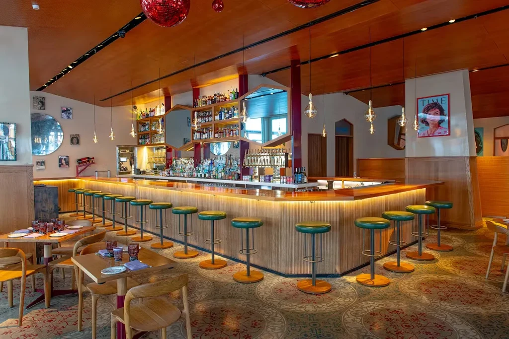 Stylish modern bar and restaurant interior with glowing bar and dining area.