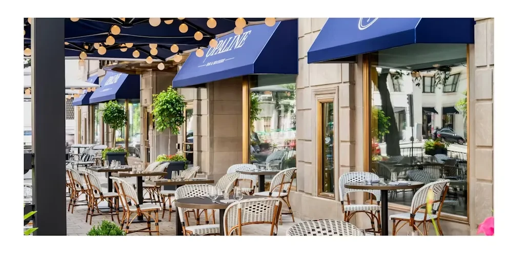 Opaline Bar & Brasserie outdoor patio with blue awnings and dining seating.