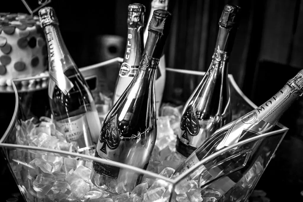 Black and white champagne bottles chilling in an ice bucket.