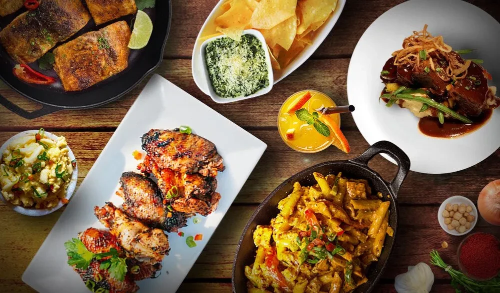 Overhead flat lay of diverse food and a drink on a rustic table.