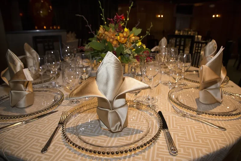 Formal round dining table with floral centerpiece and elegant place settings.