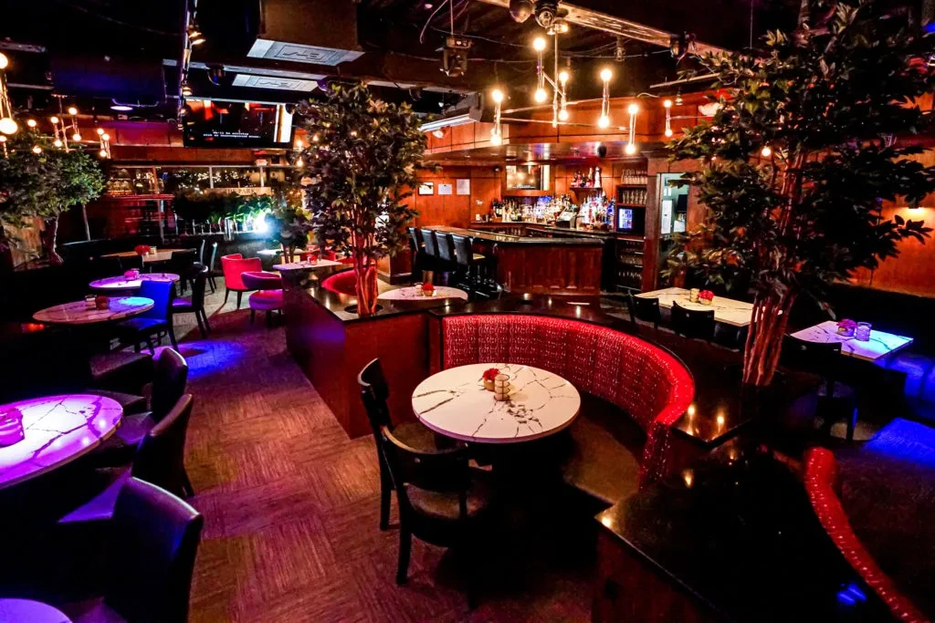 Stylish restaurant interior with a bar, varied seating, and ambient lighting.