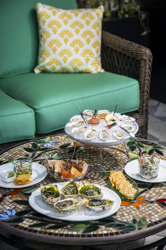A spread of seafood on a floral mosaic outdoor table.