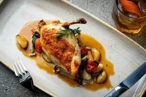 Crispy roasted chicken, spinach, potatoes, cherry tomatoes, sauce, and cocktail.
