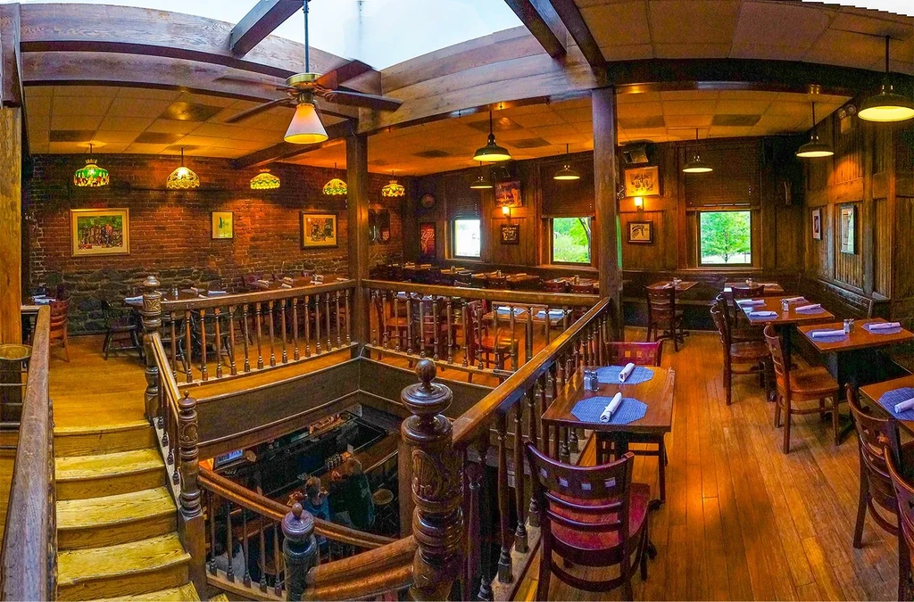 Interior view of a warm, multi-level rustic restaurant and bar.