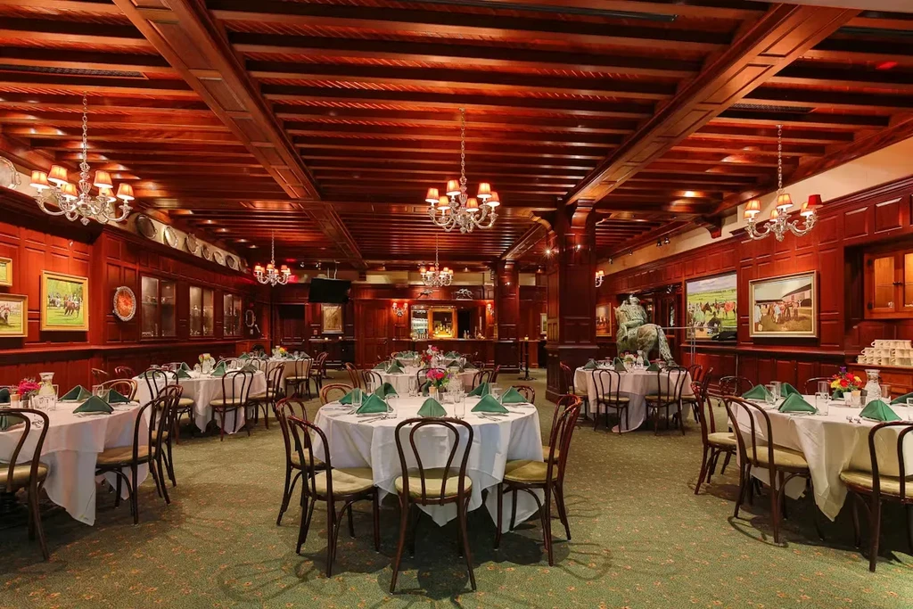 Elegant dining room featuring dark wood, chandeliers, and equestrian decor.