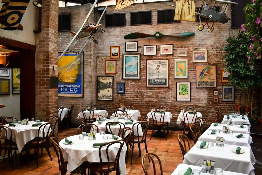 Restaurant dining room with vintage aviation decor and set tables.