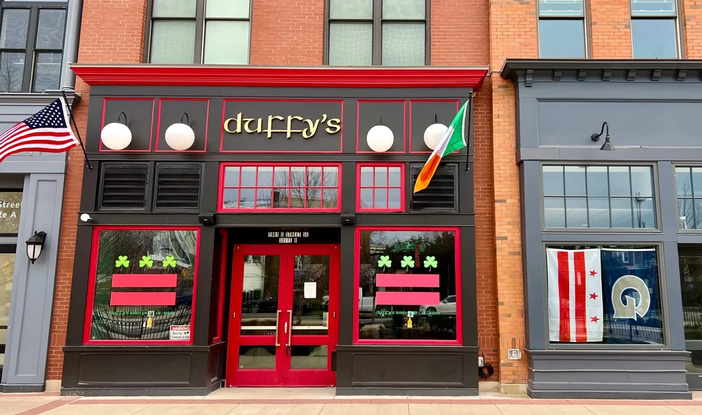 Duffy's Irish bar exterior with red brick, black facade, and flags.