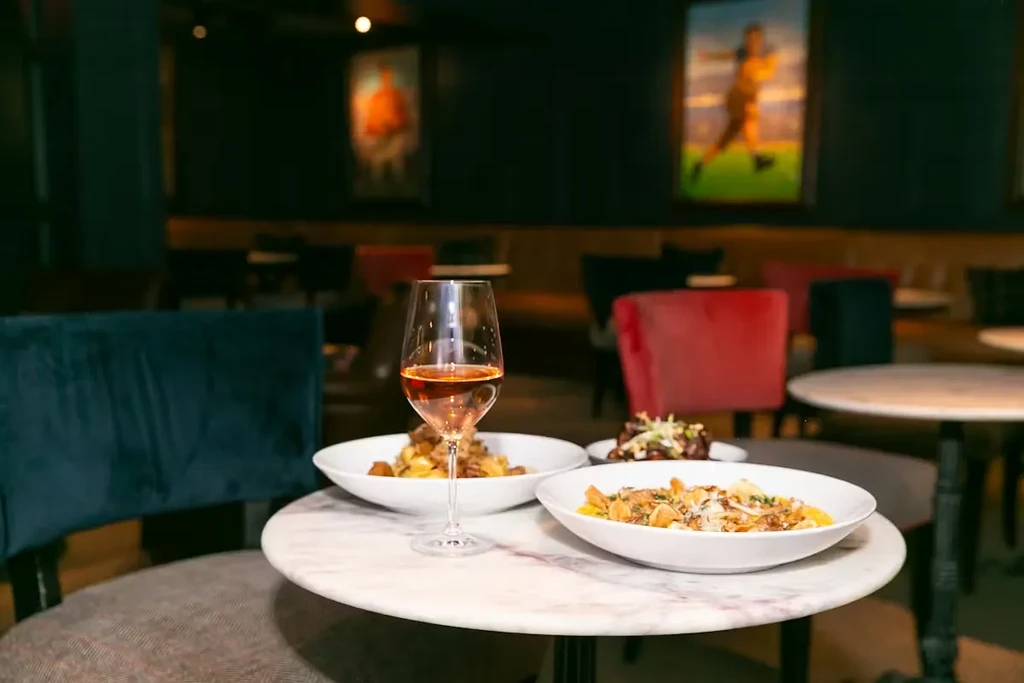 Elegant restaurant table with rosé wine and two pasta dishes.