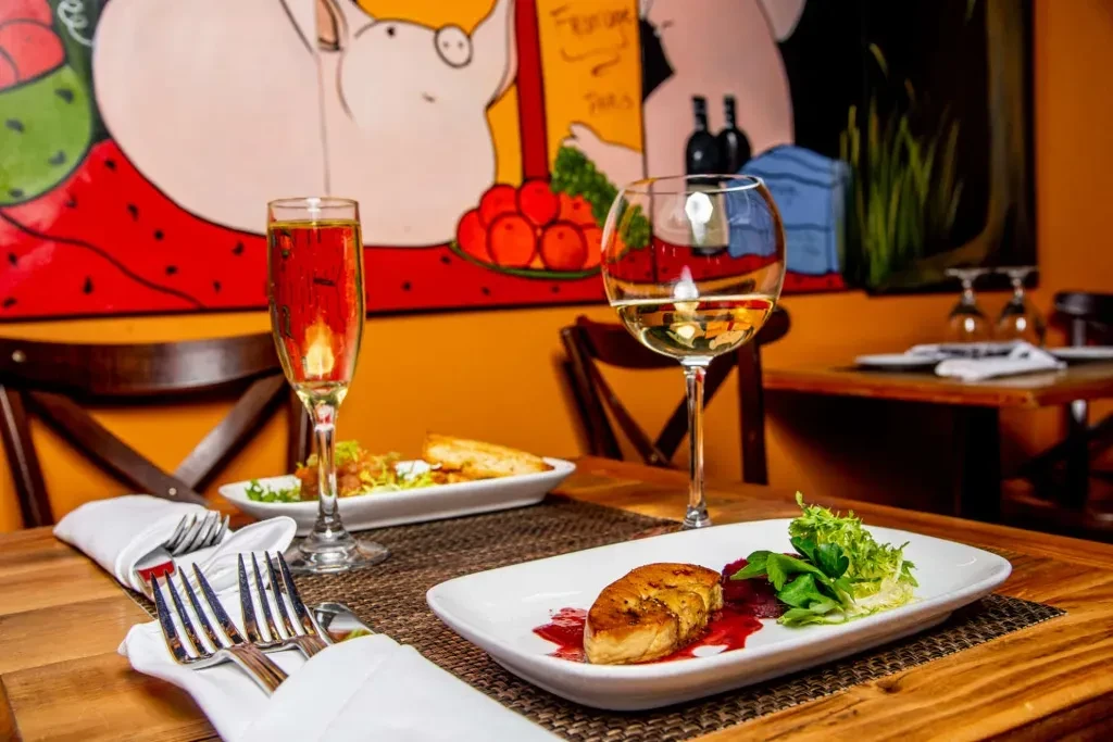 Restaurant table with food, drinks, and a colorful cartoon mural.