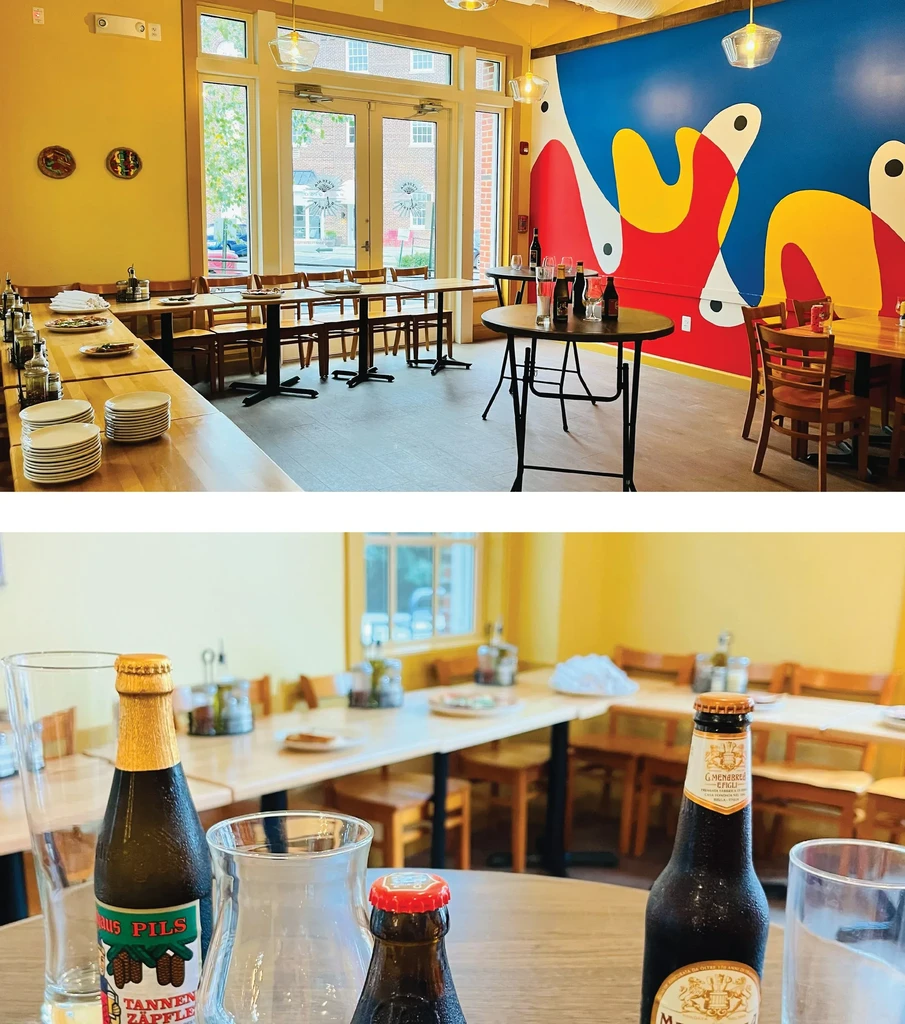 Modern restaurant interior, yellow walls, and cold beer bottles on a table.