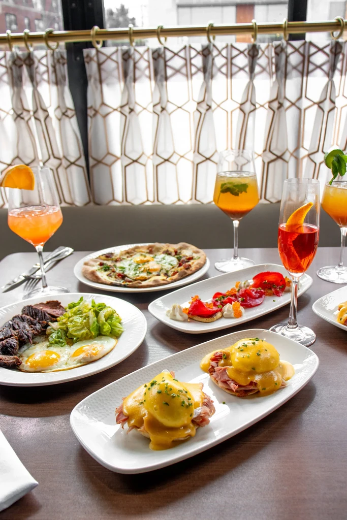 Vibrant restaurant table with diverse dishes and colorful cocktails.
