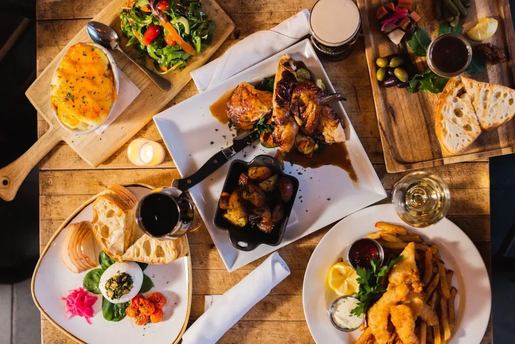 Overhead view of a rustic table spread with varied food and drinks.