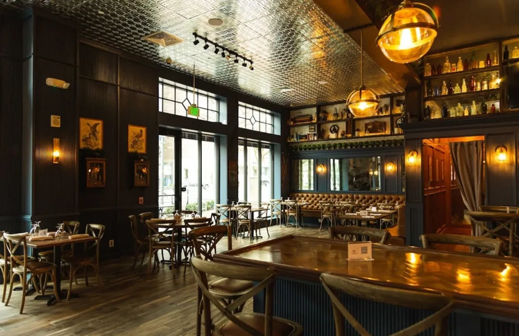 Dimly lit restaurant bar with polished wood and detailed decor.