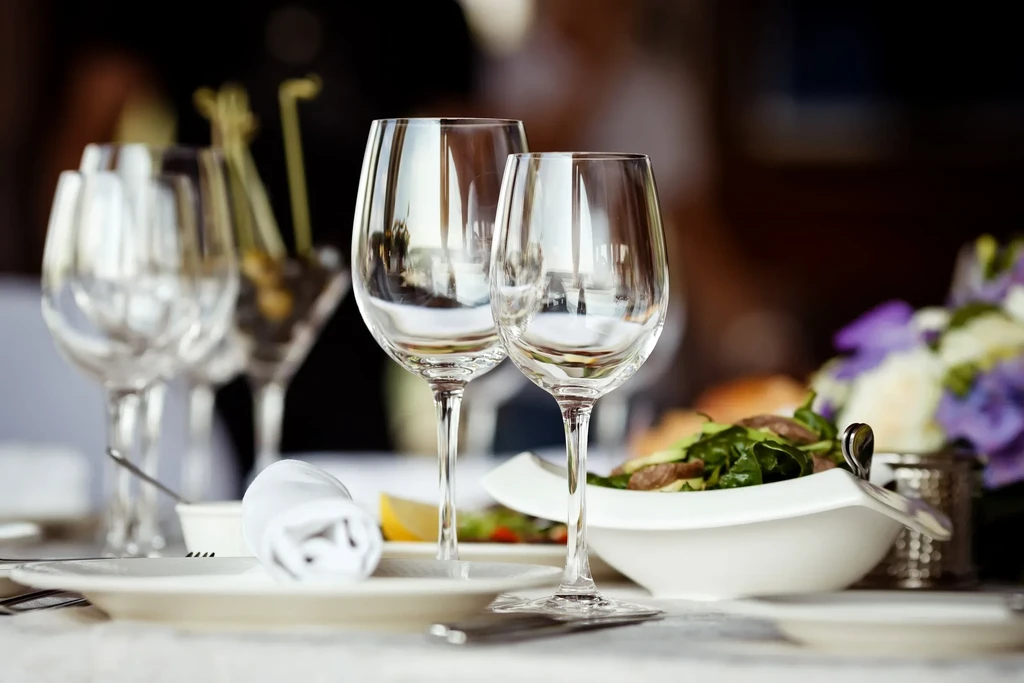 Two sharply focused empty wine glasses on an elegant dining table.