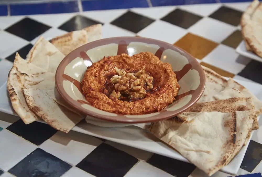 Muhammara-like dip with walnuts and oil, served with pita bread.