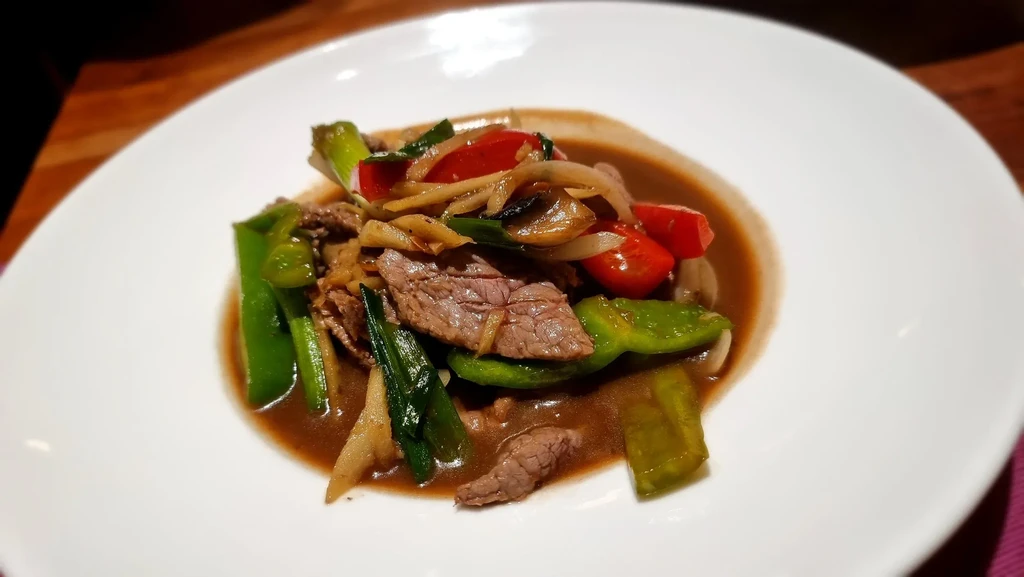 Close-up of colorful beef and vegetable stir-fry with brown sauce.