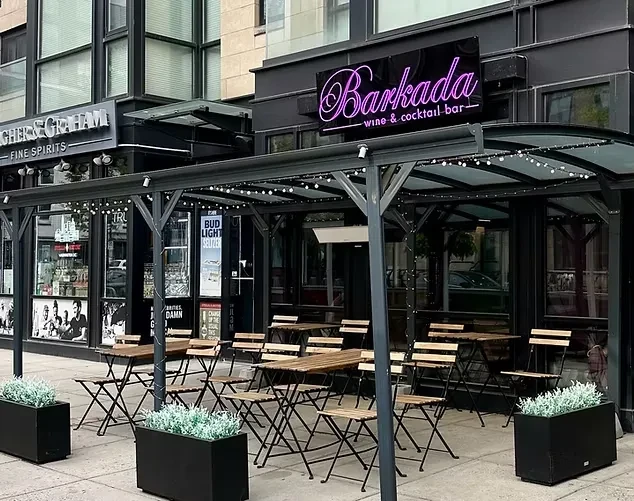 Modern Barkada Wine & Cocktail Bar exterior with patio and purple neon sign.