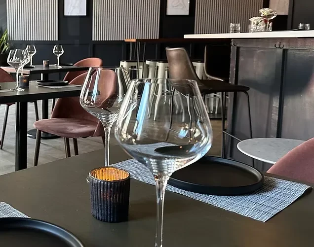 Upscale modern restaurant tables set with glasses and candles, ready for guests.