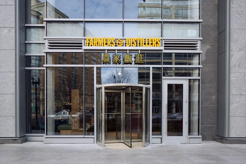 Modern glass and stone restaurant entrance with English and Chinese names.