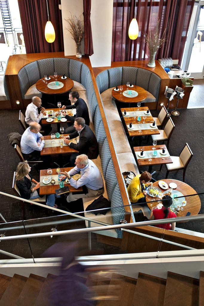 Aerial view of a busy, modern multi-level restaurant dining area.