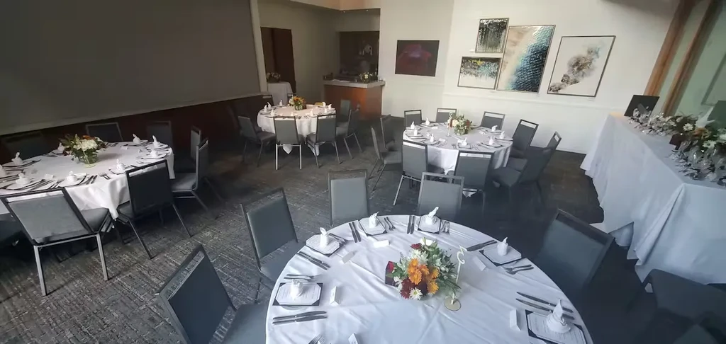 Empty elegant event space with set tables and floral centerpieces.