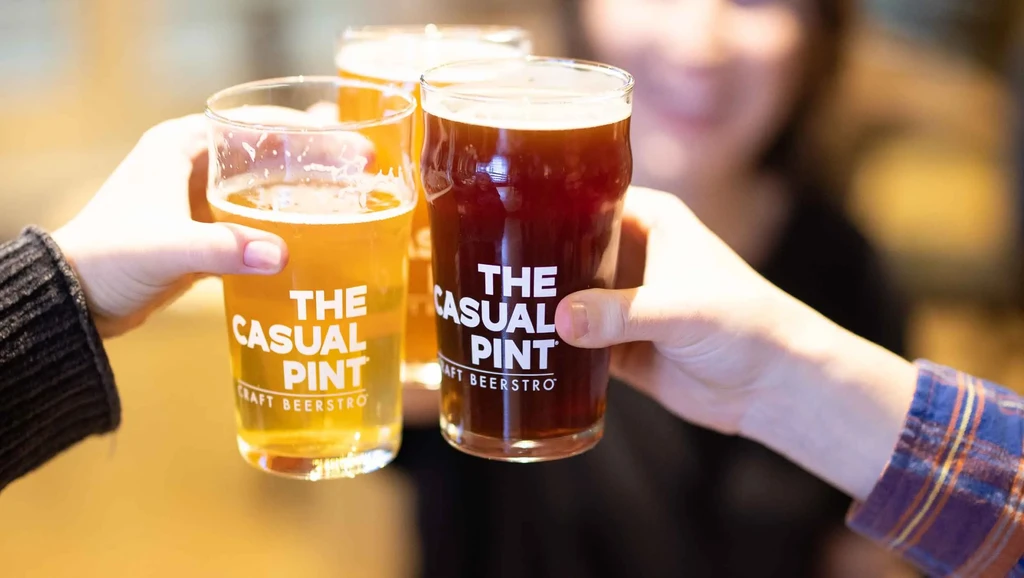 Three craft beers toasted, one light, one dark, with logo.
