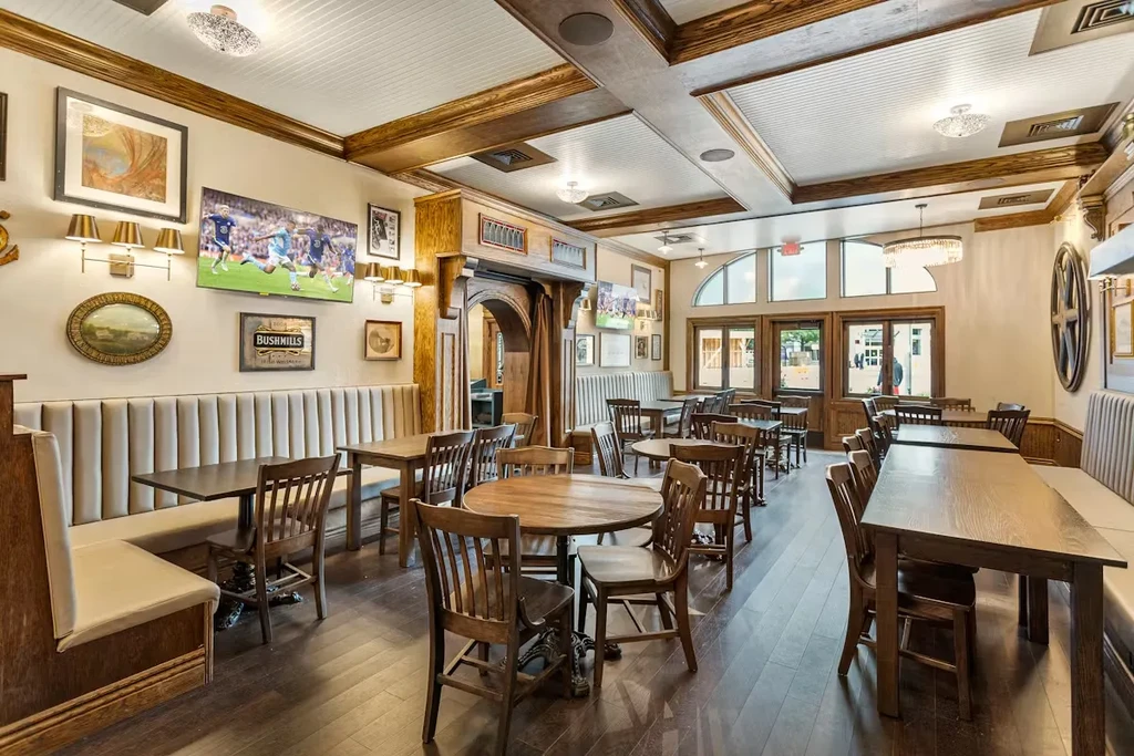 Traditional restaurant interior with booths, wooden tables, soccer on TV.