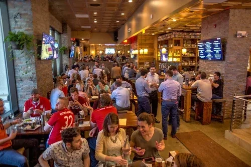 Lively, crowded modern rustic restaurant or sports bar interior.