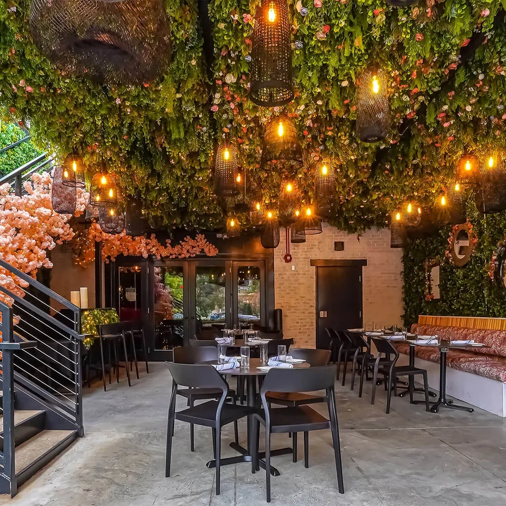 Restaurant with garden canopy ceiling, wicker lanterns, and modern dining.