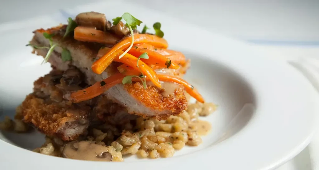 Crispy breaded cutlets over creamy spaetzle with carrots and microgreens.