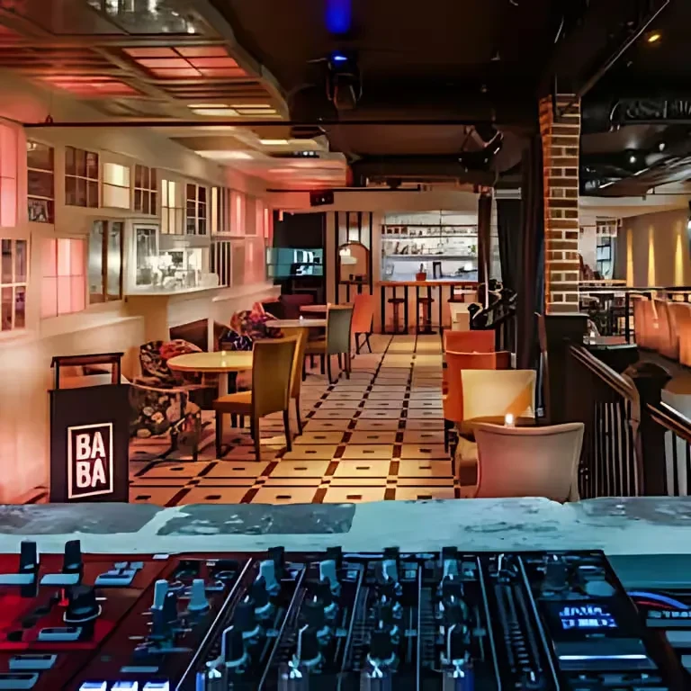 Dimly lit restaurant interior from DJ booth, showing bar and seating.