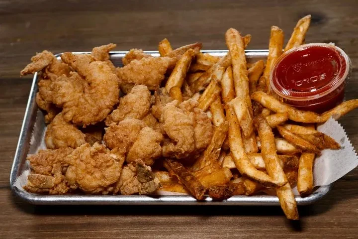 Crispy golden-brown fried food, seasoned fries, and ketchup on a tray.