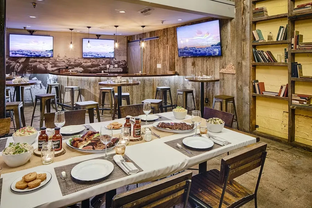 Rustic restaurant interior with barbecue dining table and bar area.