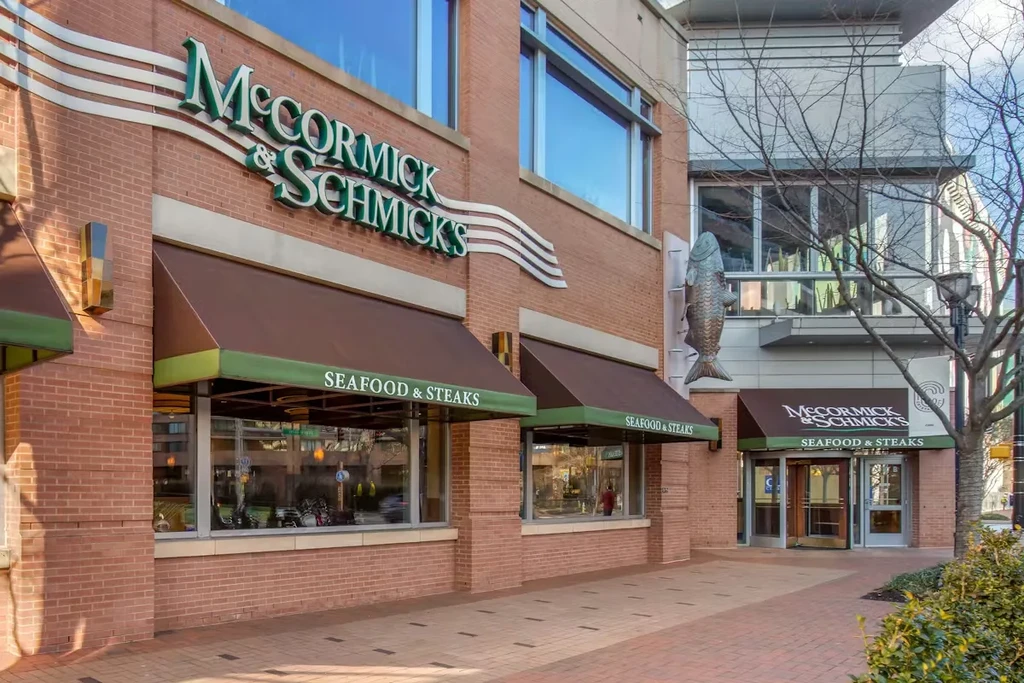McCormick & Schmick's restaurant exterior: brick building, awnings, fish sculpture.