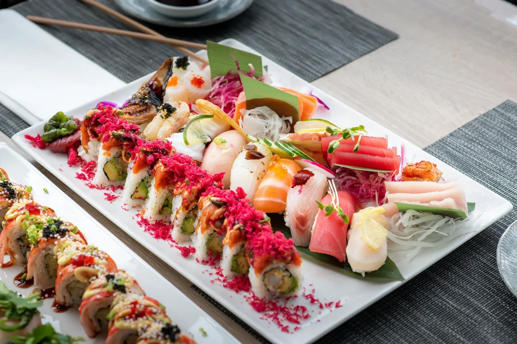 A spread of colorful Japanese sushi and sashimi on platters.