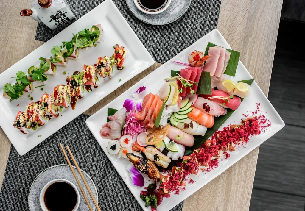 Overhead view of diverse Japanese sushi and sashimi platters.