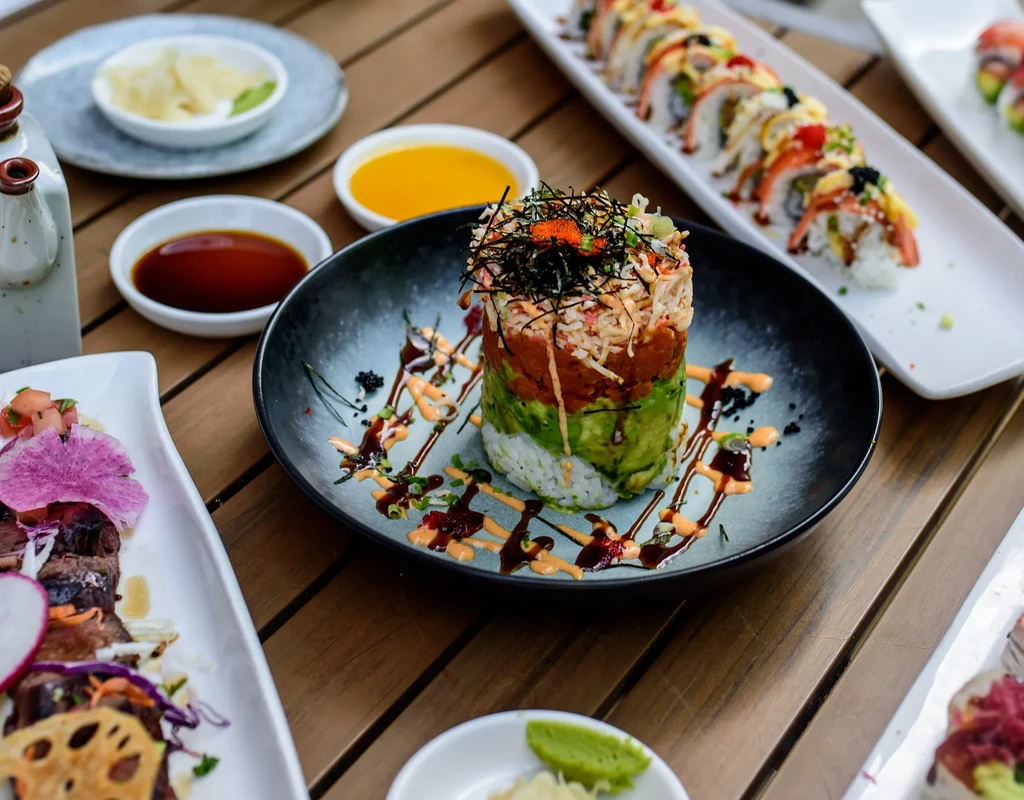 Overhead shot: vibrant Japanese sushi and poke meal on wood.